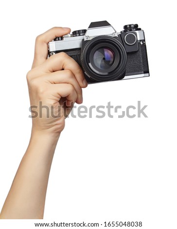 Hand holding camera isolated on white background.