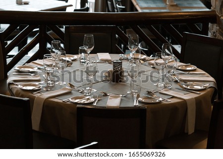 circular table in a restaurant or hotel dining room set for casual dining for eight people with low light ambience in South Africa concept table settings indoors