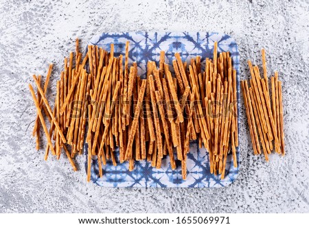 Side view crackers on blue cloth on white stone background horizontal