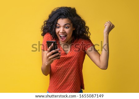 Cute female fan watching football play online broadcast cheering for her favourite team and making winner gesture with her fist being happy about the score. Gambler girl celebrating victory making bet Royalty-Free Stock Photo #1655087149