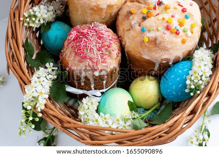 Easter cakes. Easter eggs in a wicker basket. white cherry flowers. homemade easter baking