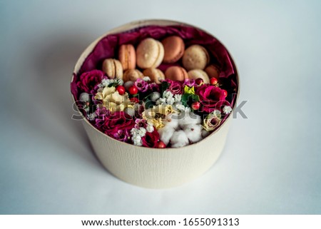Gift or present with flower and french macaroons on grey background with copy space. Rustic style. Toned image.