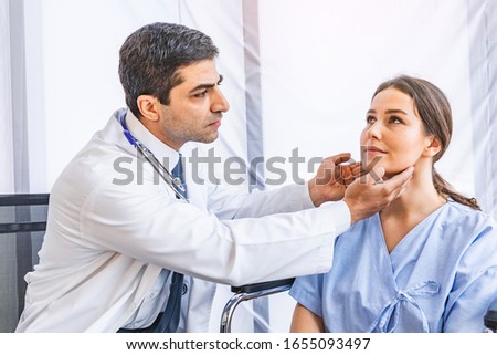 Asian doctor check-up pretty patient for her Thyroid hormones healthy at hospital or medical clinic, Health care and Medical concept Royalty-Free Stock Photo #1655093497