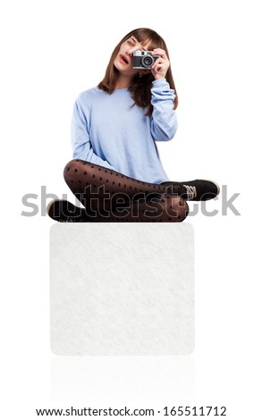 young woman taking a photo sitting on a box isolated on white