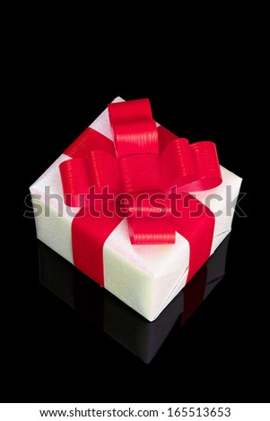 White Silver Gift Box with Red Ribbon Bow with Reflection on Black Background