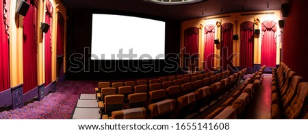 Cinema theater screen in front of seat rows in movie theater showing white screen projected from cinematograph. The cinema theater is decorated in classical style for luxury feeling of movie watching. Royalty-Free Stock Photo #1655141608