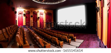 Cinema theater screen in front of seat rows in movie theater showing white screen projected from cinematograph. The cinema theater is decorated in classical style for luxury feeling of movie watching. Royalty-Free Stock Photo #1655141614