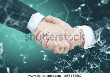 Handshake on green creative polygonal background. Communication and teamwork concept. Close up