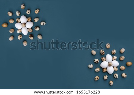 Simple easter minimalistic picture card. Flower composition of white chicken and quail eggs on the bright dark blue background with copy space in the center.