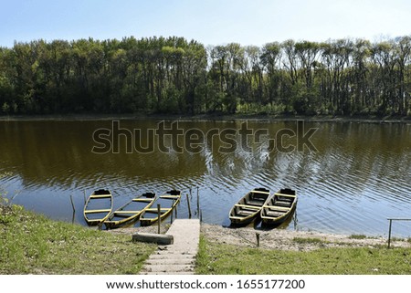 Boats on the river , black and yellow colors - three almost sink