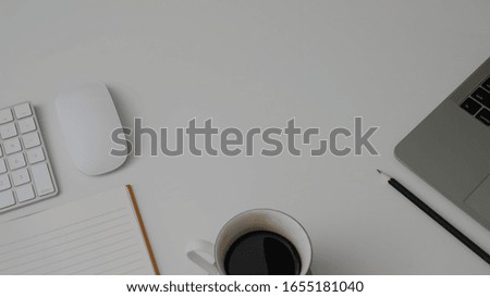 Cropped shot of minimal workspace with laptop, wireless computer device, coffee cup, stationery and copy space on white table background