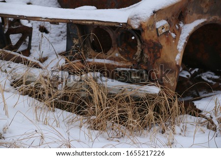 abandoned rusty car in the snow