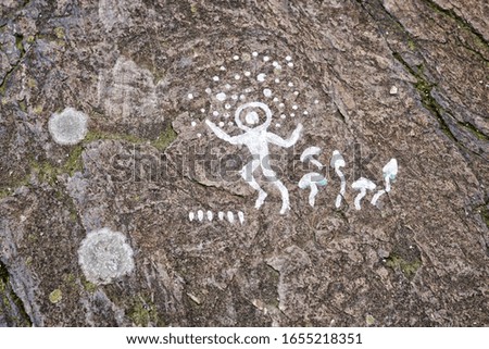 Painted person and magic mushrooms on the stone with moss