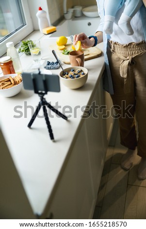 Woman holding baby while using smartphone for blog stock photo