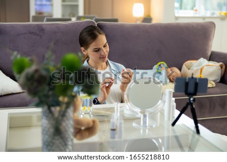 Happy young mother doing manicure while making video for blog stock photo