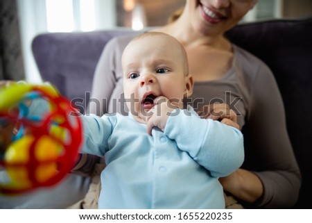 Happy beautiful motehr looking at her kid and enjoying time together at home stock photo