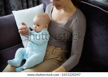 Top view of happy mother holding her newborn child while sitting and resting at home stock photo