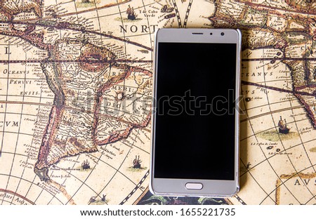  gold smartphone lies on a vintage world map, travel and travel theme, business tourism, a combination of vintage style and modernity