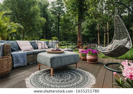 Garden patio decorated with Scandinavian wicker sofa and coffee table Royalty-Free Stock Photo #1655251780