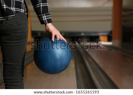 Woman with ball in bowling club, closeup. Space for text