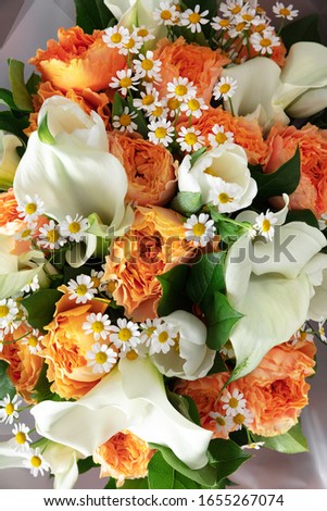 Close up of fashion modern bouquet of different flowers on wooden background. Masterclass. Gift for bride on wedding, mother's, woman's day. Romantic spring fashion. Bright colors of feelings.