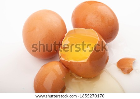Broken chicken egg and chicken eggs on a white background. Close up.