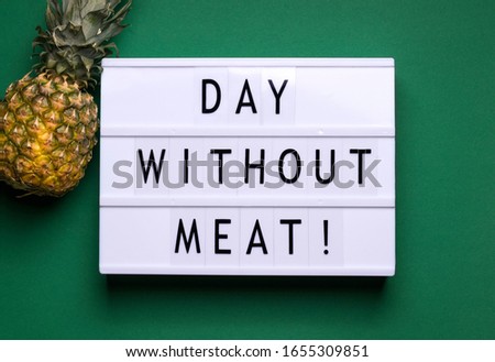 on a green background there is a lightbox with text and a fruit announcement next to it. International Day Without Meat concept