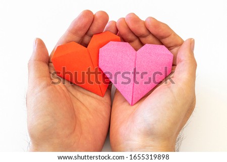 Man hand with heart made of origami