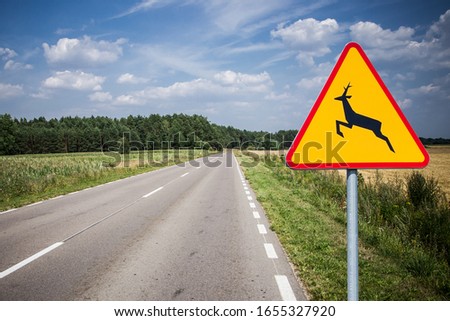 The Deer Crossing Warning sign. Dangerous accident may happen even on empty road. Be careful animals on the asphalt road.