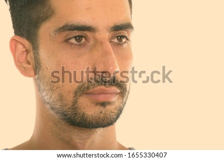 Close up of young Persian man thinking while looking at distance