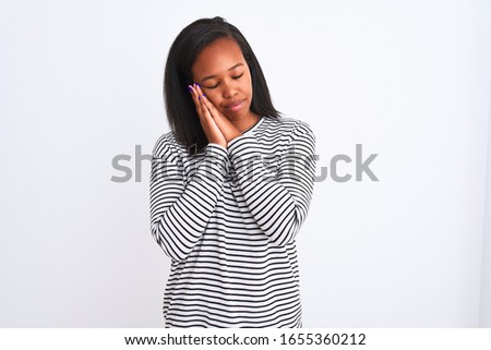 Beautiful young african american woman wearing winter sweater over isolated background sleeping tired dreaming and posing with hands together while smiling with closed eyes.