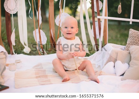 Little blond girl playing and posing on photo zone outdoors