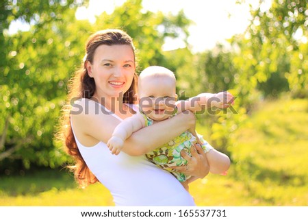 Beautiful Mother And Baby outdoors. Nature. Beauty Mum and her Child playing in Park together