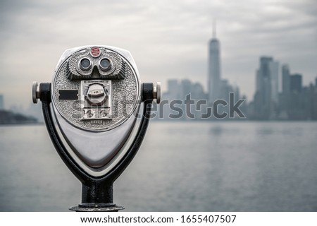 Binoculars with downtown Manhattan skyline on cloudy day in background