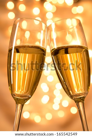 Pair of champagne flutes over gold background 