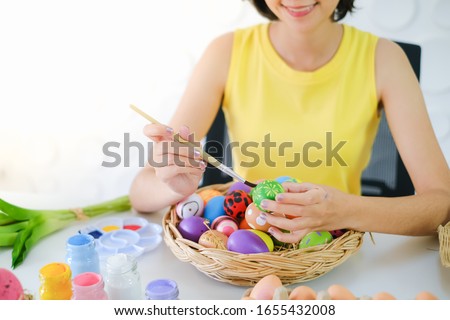 Portrait young girl painting easter egg