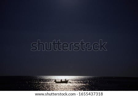 Three fishermen in a boat, Goa, India
