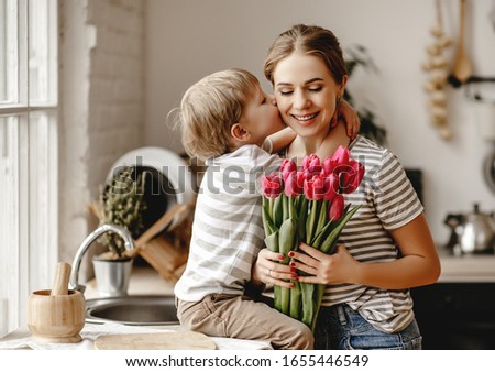 happy mother's day! child son congratulates mother on holiday and gives flowers
