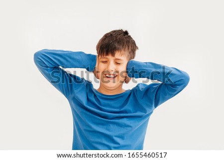boy pointing fingers at copy space looking at camera,child astonished excited advertising product or service isolated on white blank studio background