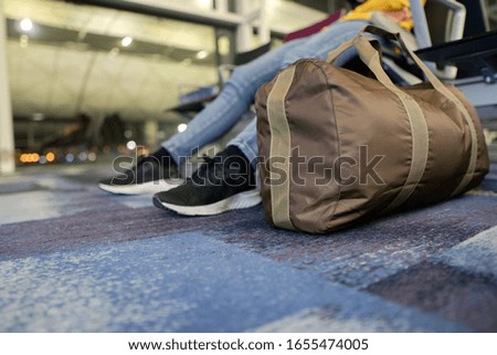 Young woman at international airport, waiting for her flight. Female passenger at terminal, indoors.