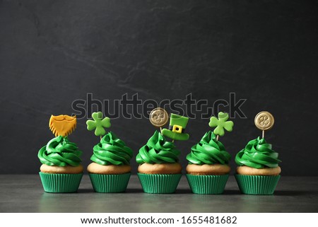 Delicious decorated cupcakes on grey table. St. Patrick's Day celebration