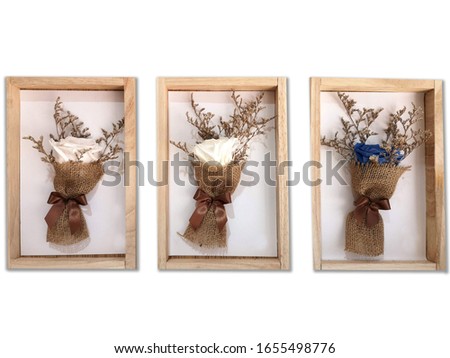 A bouquet of flowers in the picture frame as a home decoration.