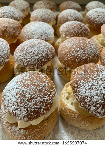 Tasty delicious cream bun with cream and icing sugar standing together on a table in a staffroom in Helsingborg, Sweden.