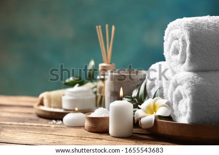 Beautiful spa composition with plumeria flower on wooden table. Space for text Royalty-Free Stock Photo #1655543683