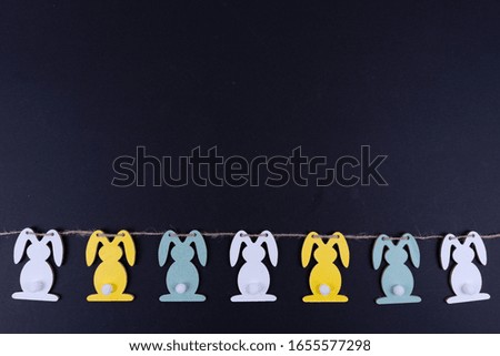 A row of colorful easter bunnies on black background with copy space