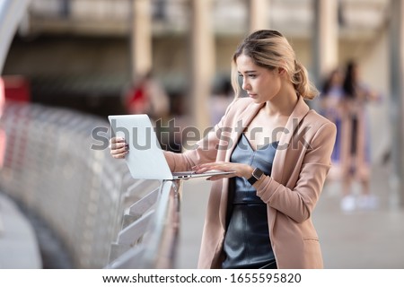Businesswoman blonde hair standing working with laptop outdoor office. 