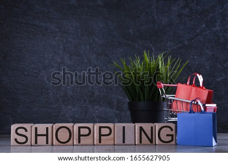 Shopping concept. Wooden cubes with word shopping on the dark background with shopping basket