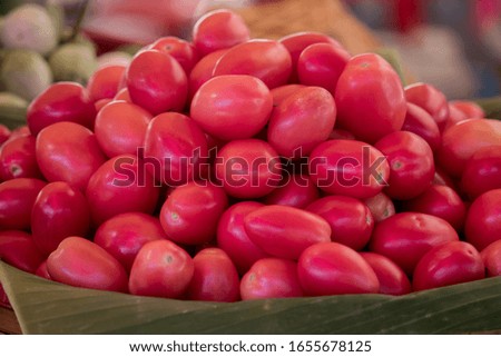 Close up of fresh ripe small tomatoes for somtum food in basket at market.