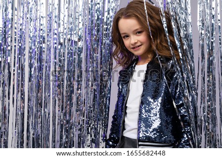 Caucasian cute teenage girl in a stylish festive image on a birthday against the background of a bright photo zone