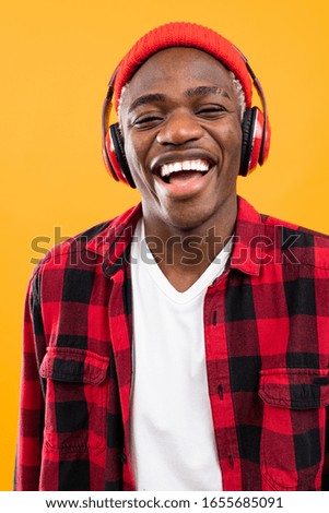 handsome smiling black american man listening to music using headphones